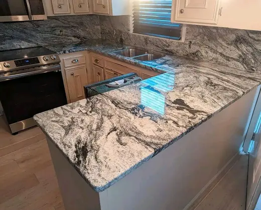 Patterned kitchen island surface beside dark cabinetry