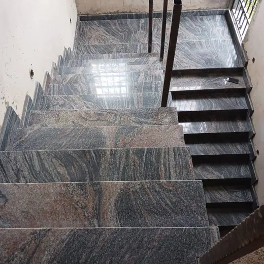 Polished dark staircase with patterned risers and landing