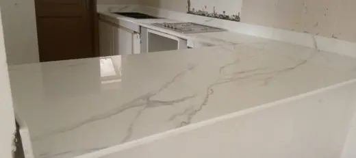 Long pale veined vanity surface with a basin opening