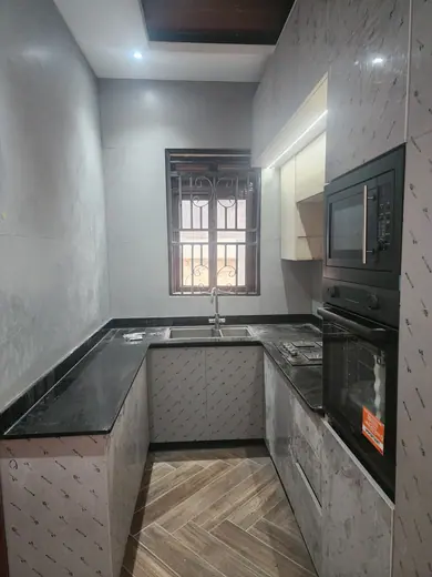 Dark worktop fitted into a kitchen corner beneath a window