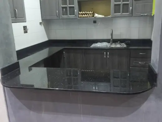 Dark L-shaped kitchen worktop with a central sink opening