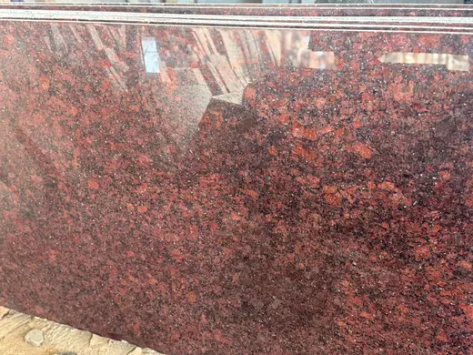 Close view of a dark red mottled stone surface