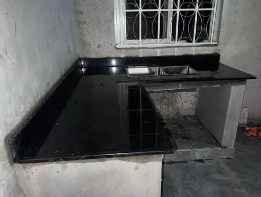 Dark worktop wrapping around a compact kitchen corner
