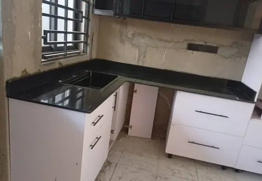 Dark kitchen worktop with sink and white lower cabinets