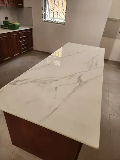 Pale veined surface extending across a kitchen island