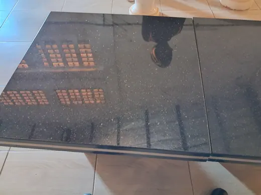 Glossy black surface reflecting nearby buildings