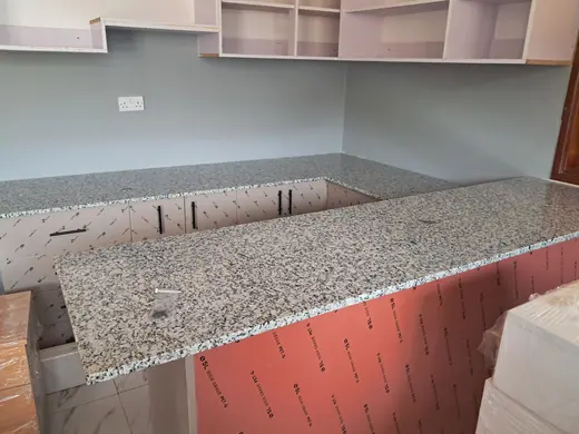 Speckled worktop laid over an unfinished base