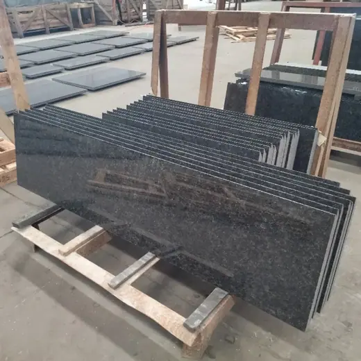Dark rectangular stone pieces stacked in a yard