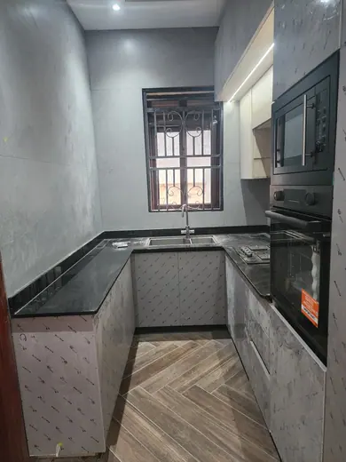 Grey worktop around a sink in a bright kitchen