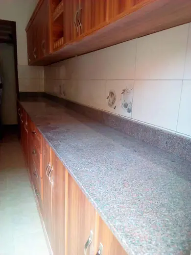 Brown patterned sill or ledge beneath a tiled wall