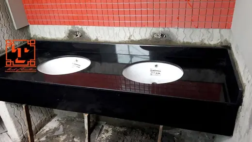 Two basin openings in a dark red vanity top