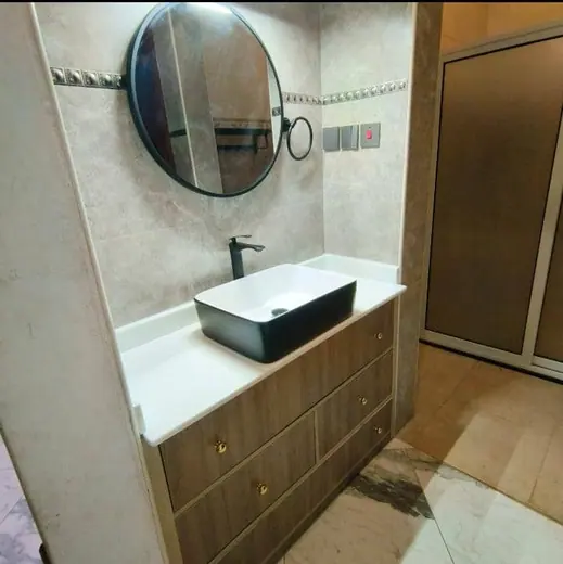 Rectangular white basin on a dark bathroom vanity