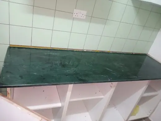 Green-toned surface fitted beneath a tiled wall