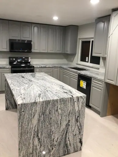 Large pale patterned kitchen island viewed from one end