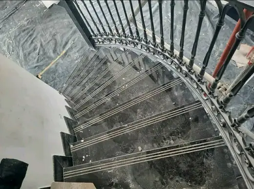 Curved interior staircase with patterned stone treads