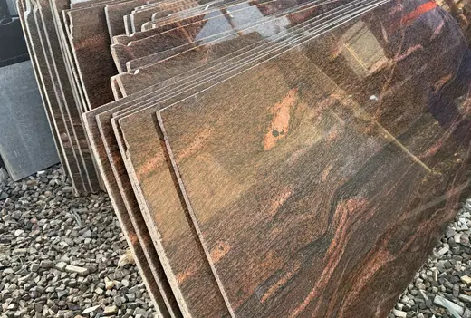 Upright reddish-brown veined slabs at a yard