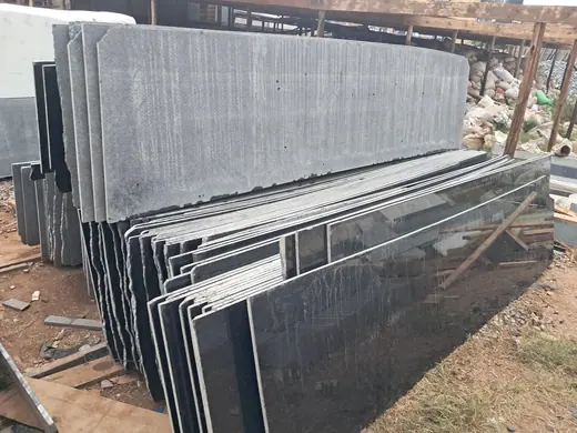 Rows of upright dark stone slabs in a storage yard