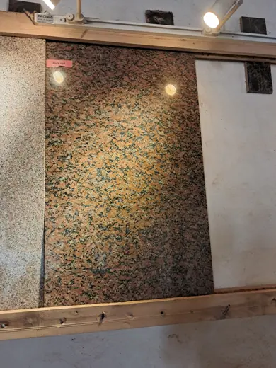 Speckled stone slab displayed upright against a wall